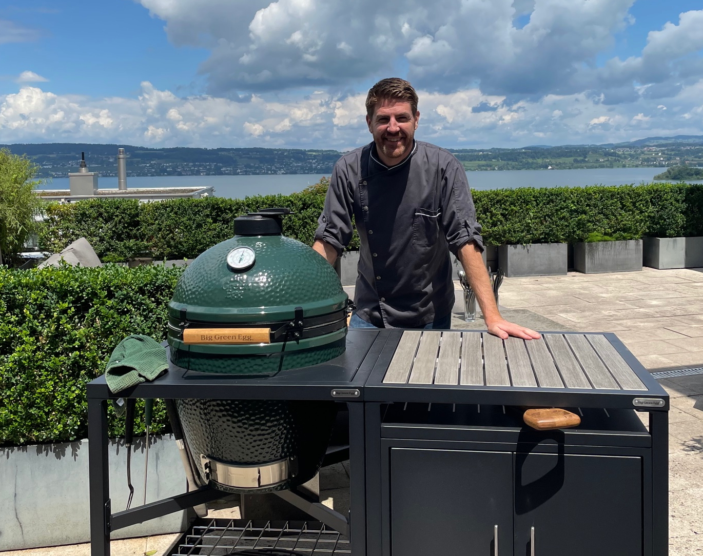 Big Green Egg Head Kevin Feierabend in Pfäffikon SZ mit toller Aussicht auf den Zürichsee. Hier mit einem Big Green Egg Modularem Tischsystem, der Outdoorküche für das Big Green Egg.